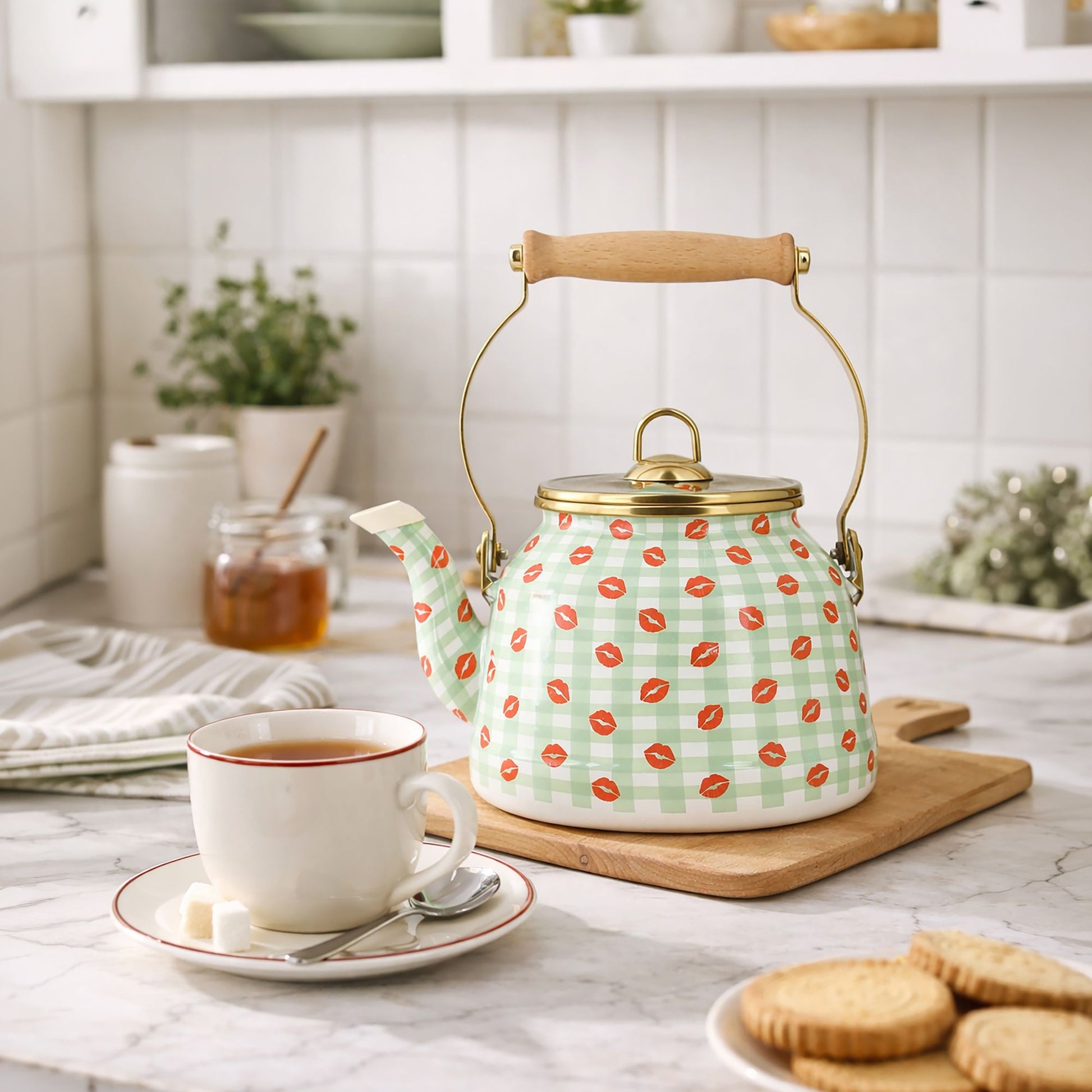 Bouilloire Vichy 2.5L en acier émaillé motif carreaux verts et bisous rouges, posée sur planche en bois avec tasse de thé