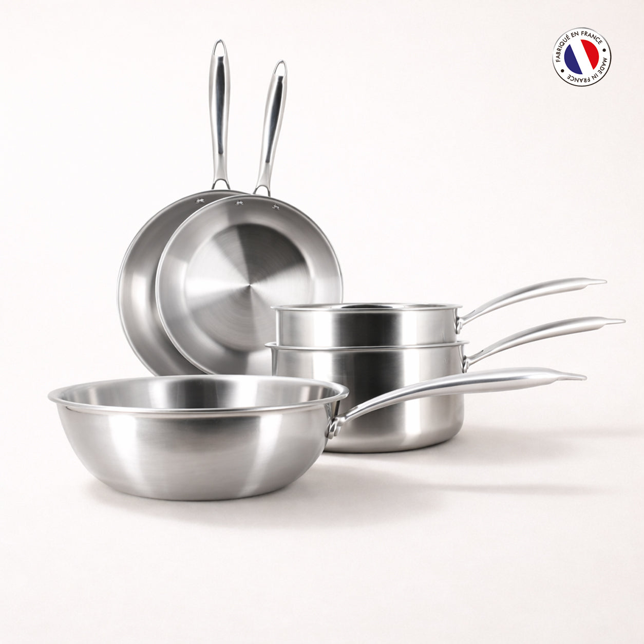 Set de 5 pièces Triply Menastyl en acier inoxydable : 2 poêles, 2 casseroles et 1 wok, vue d'ensemble sur fond blanc