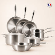 Set de 8 pièces Triply Menastyl en acier inoxydable, poêles casseroles et faitouts disposés sur fond beige