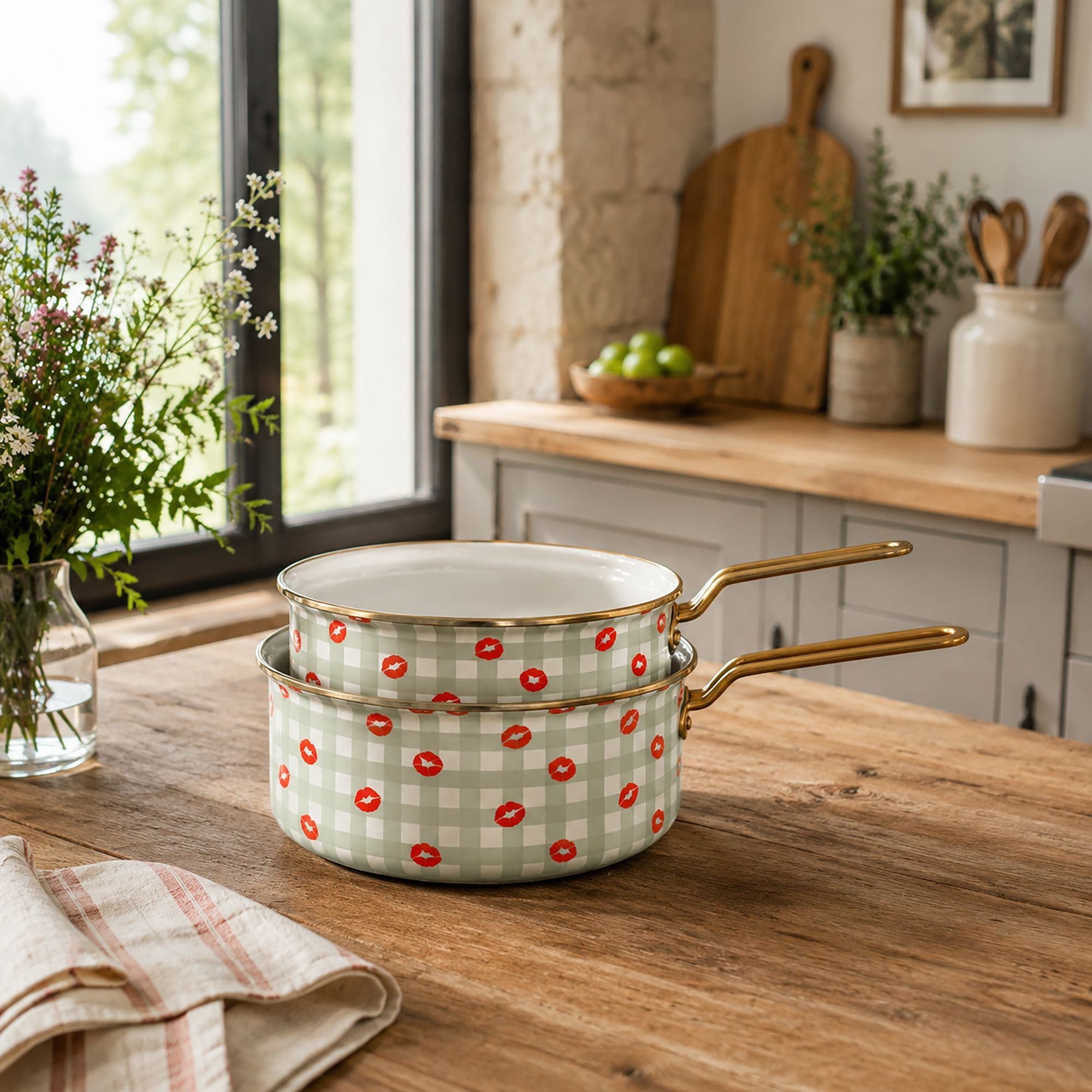 Lot de 2 casseroles Vichy en acier émaillé motif carreaux beiges et bisous rouges, poignées dorées, sur table en bois