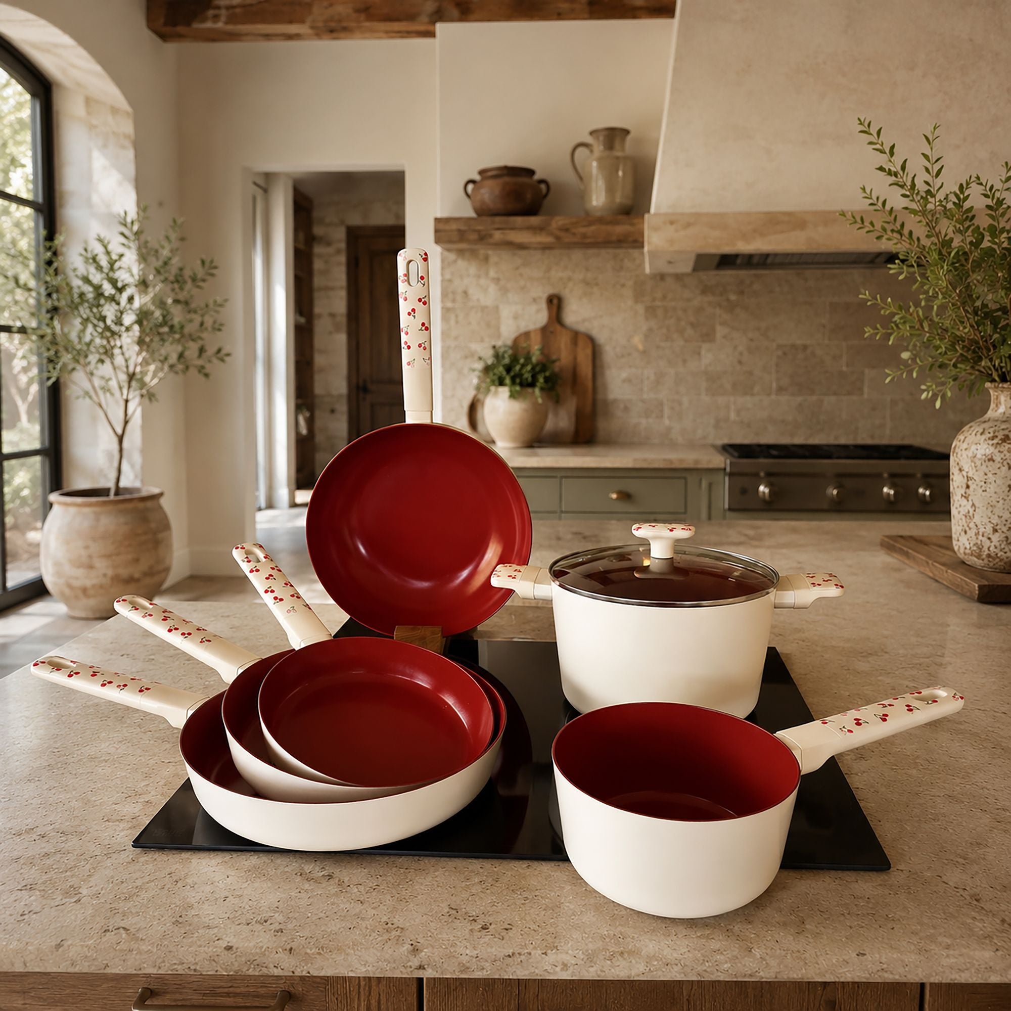 Set de 6 pièces Cerise en aluminium blanc et rouge disposé sur îlot de cuisine, détail des ustensiles avec motif cerise