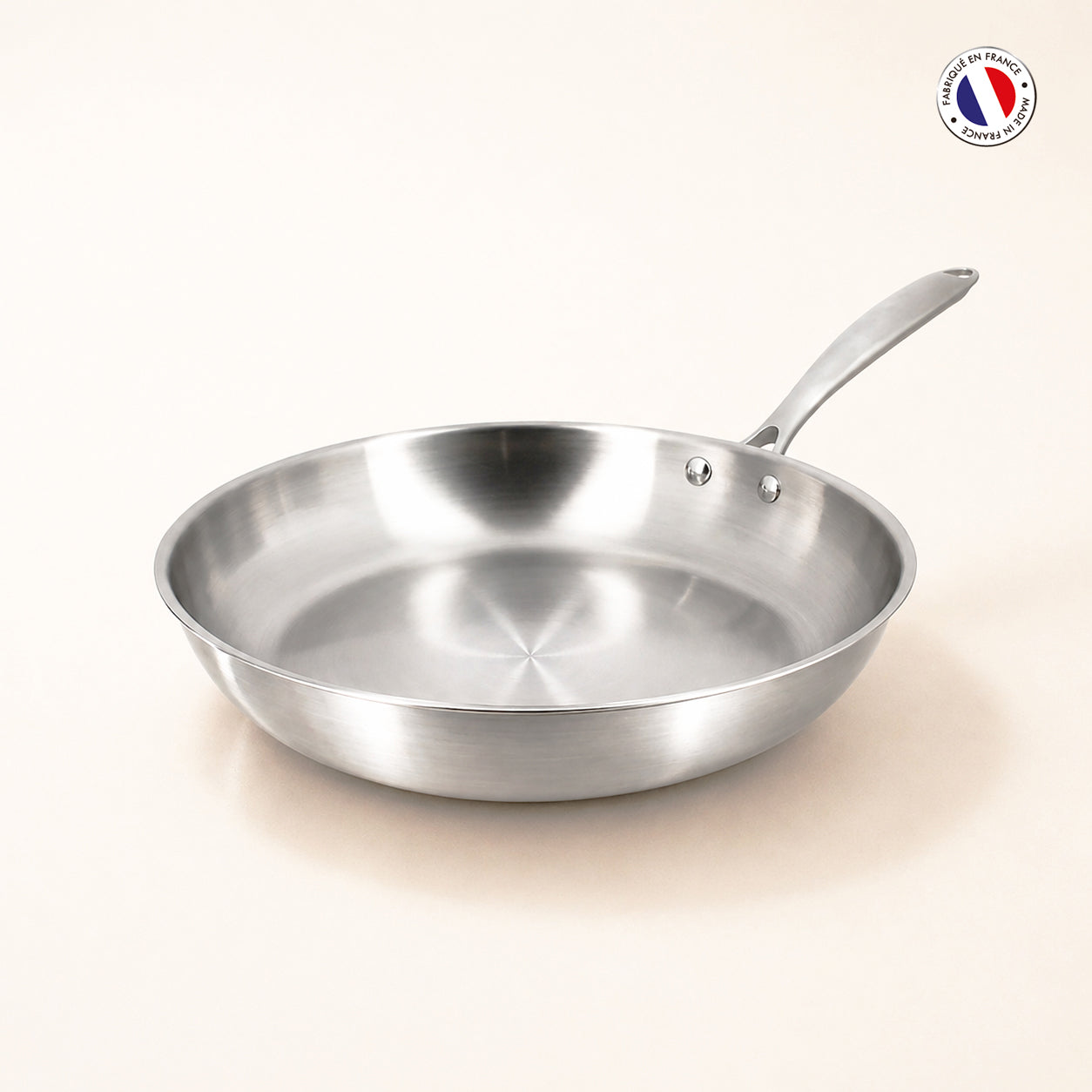 Poêle Triply 20cm en acier inoxydable triple couche Menastyl, vue de trois quarts sur fond clair