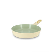 Poêle Citron 20cm en aluminium Menastyl, extérieur jaune pastel et intérieur vert amande, vue de trois quarts avec manche perforé