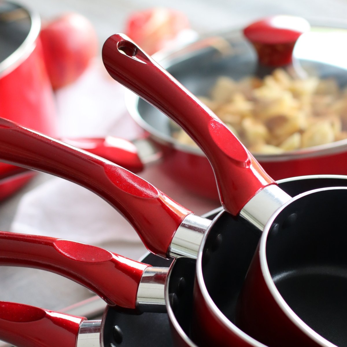 Détail des manches rouges cerise ergonomiques des casseroles en aluminium avec anneau chromé