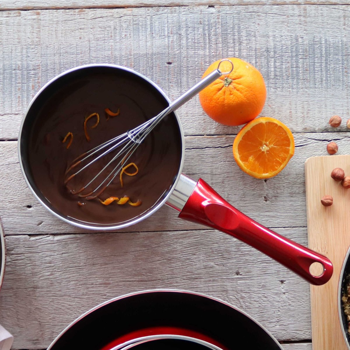 Casserole Cerise rouge 18cm avec fouet, chocolat à l'orange, ambiance cuisine sur bois rustique