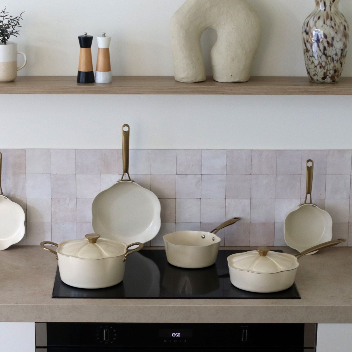 Casseroles Dahlia beige avec couvercles et poêles en aluminium recyclé, disposées sur plaque induction dans cuisine moderne