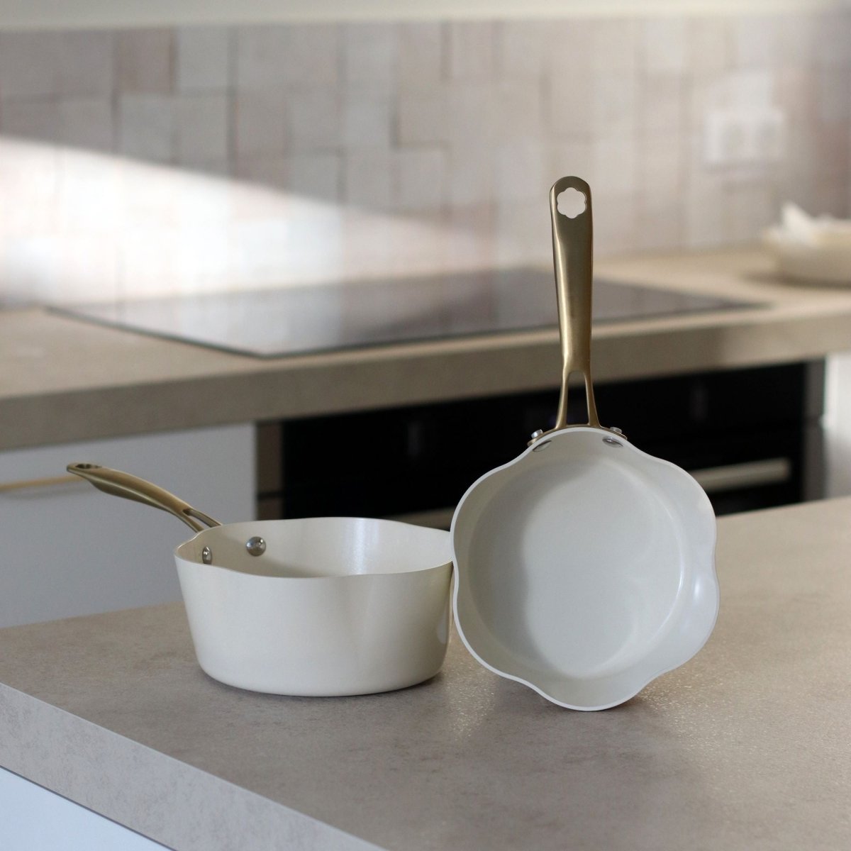Deux casseroles Dahlia beige en aluminium recyclé posées sur plan de travail, vue intérieure et design élégant
