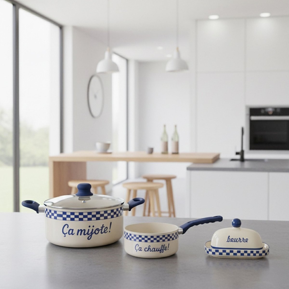 Set de 3 ustensiles Ginette blanc crème à carreaux bleus posé sur plan de travail gris dans cuisine moderne