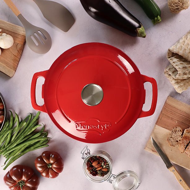 Vue de dessus cocotte en fonte rouge Colette 7 litres avec couvercle, entourée d'ingrédients frais sur plan de travail