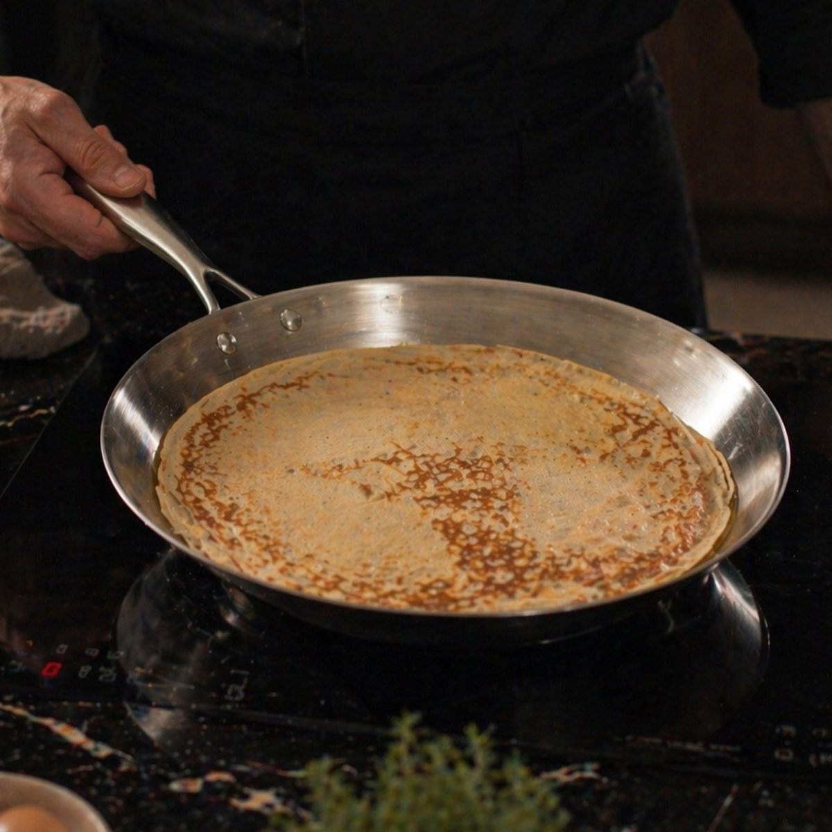 Crêpière Triply 28cm en acier inoxydable sur plaque de cuisson, crêpe en train de cuire