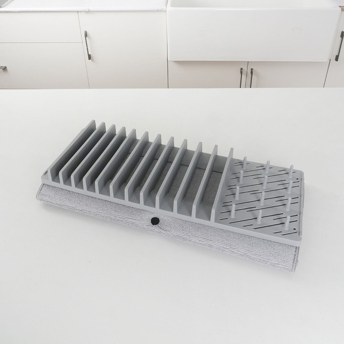 Égouttoir à vaisselle gris en polypropylène avec séparateurs amovibles et tapis polyester, vue d'angle sur plan blanc