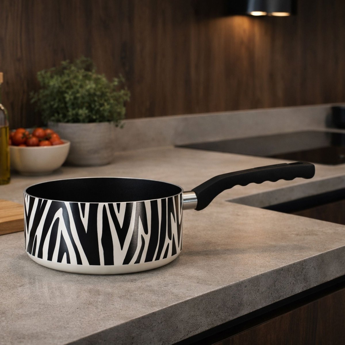 Casserole zèbre en aluminium et céramique sans PFAS, posée sur plan de travail gris, vue latérale avec poignée noire