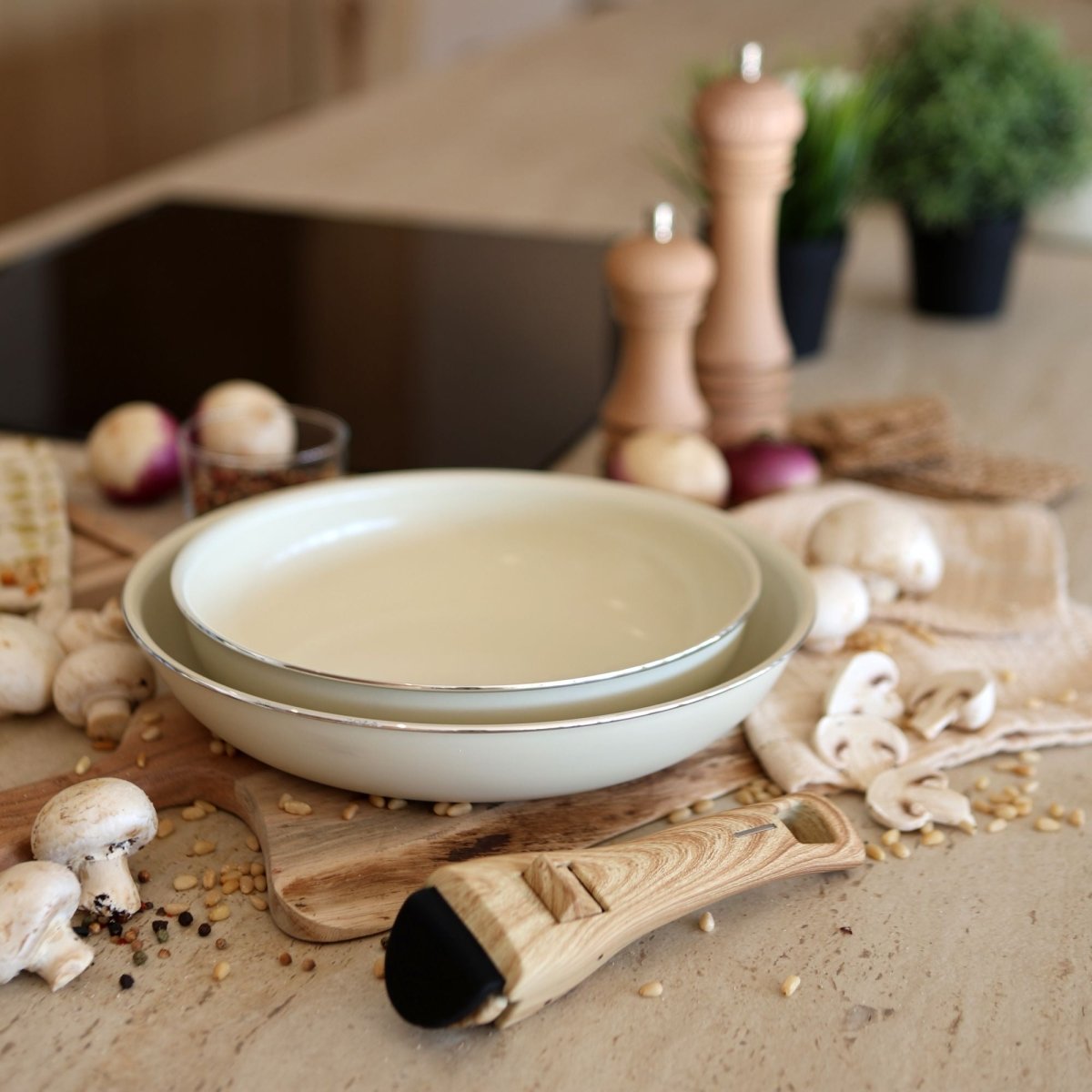Poêle Colorama en aluminium recyclé posée sur planche en bois avec champignons et ingrédients de cuisine