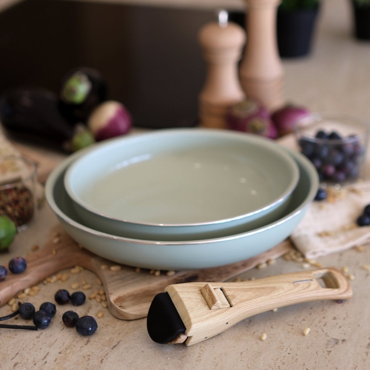 Lot de 2 poêles Colorama empilées avec poignée amovible en bois, mise en scène cuisine avec fruits et épices