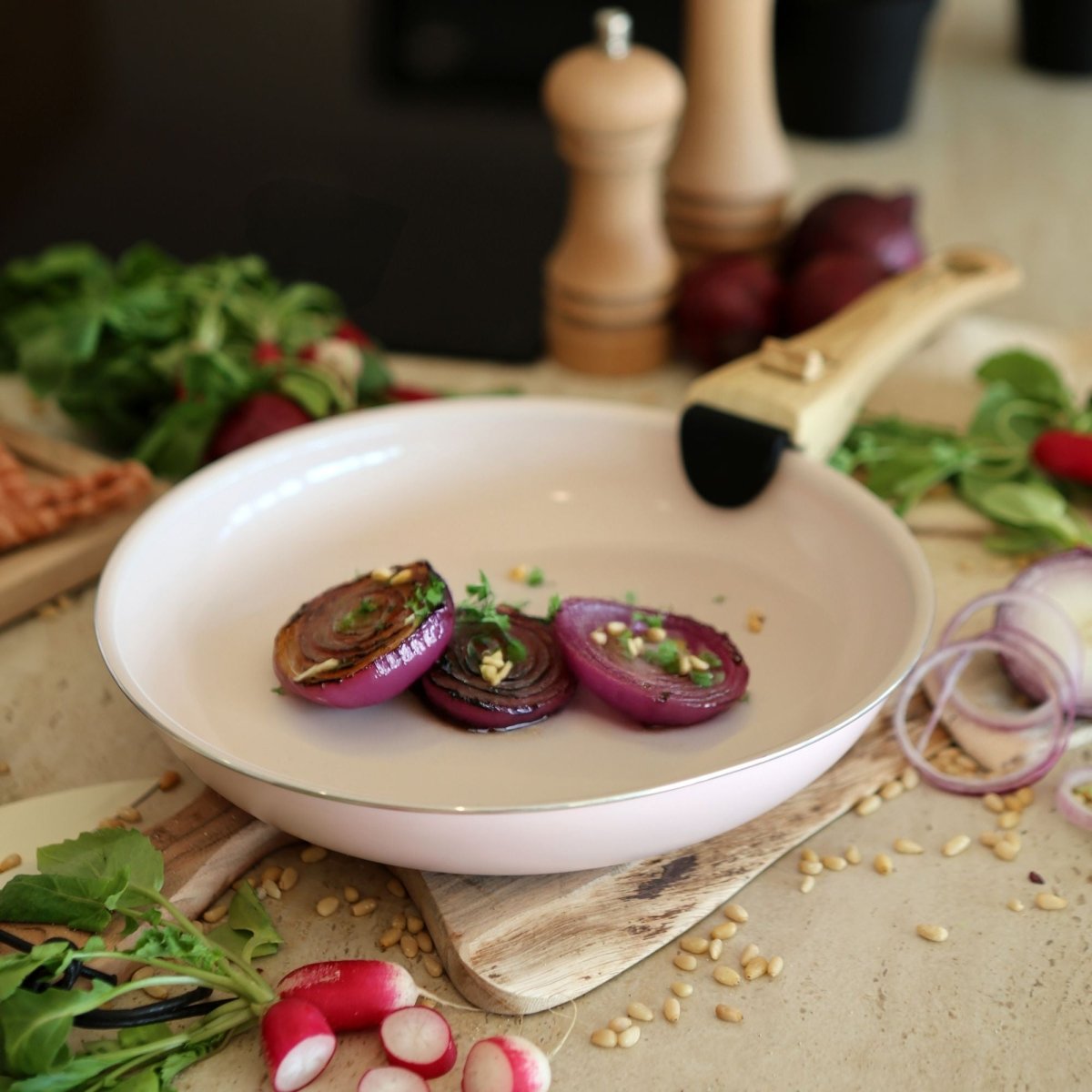 Oignons rouges grillés dans une poêle, accompagnés d'aromates et ingrédients frais sur planche bois