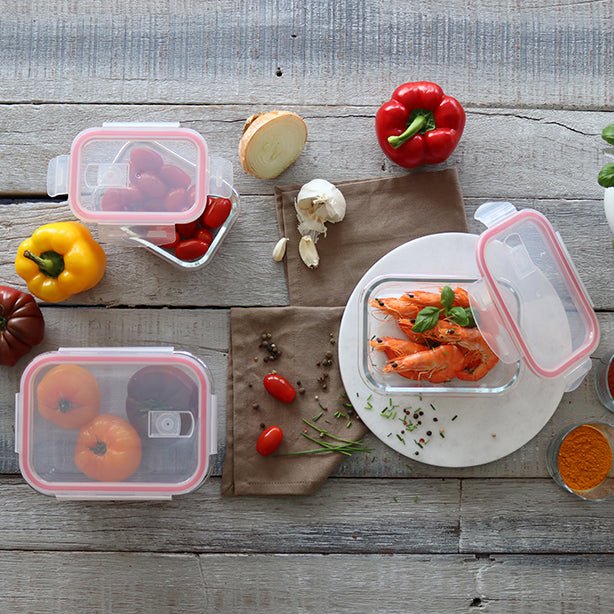 Boîtes hermétiques Clémentine avec couvercle rose contenant des légumes frais et crevettes, disposées sur table en bois