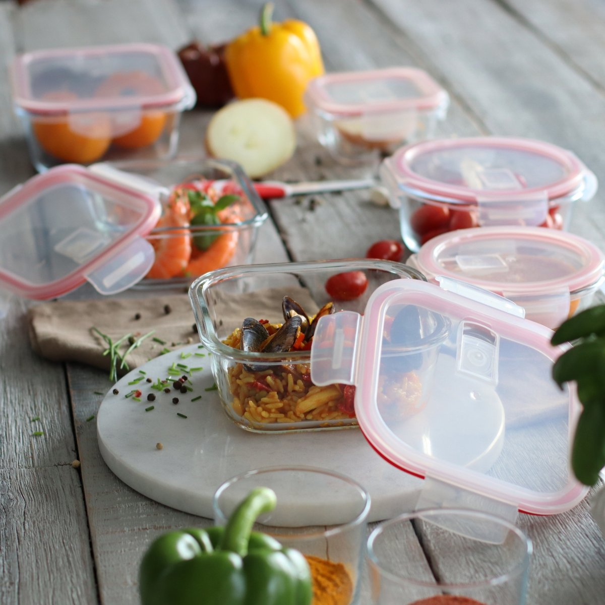 Lot de 6 boîtes hermétiques en verre avec couvercles roses contenant différents aliments sur table en bois rustique