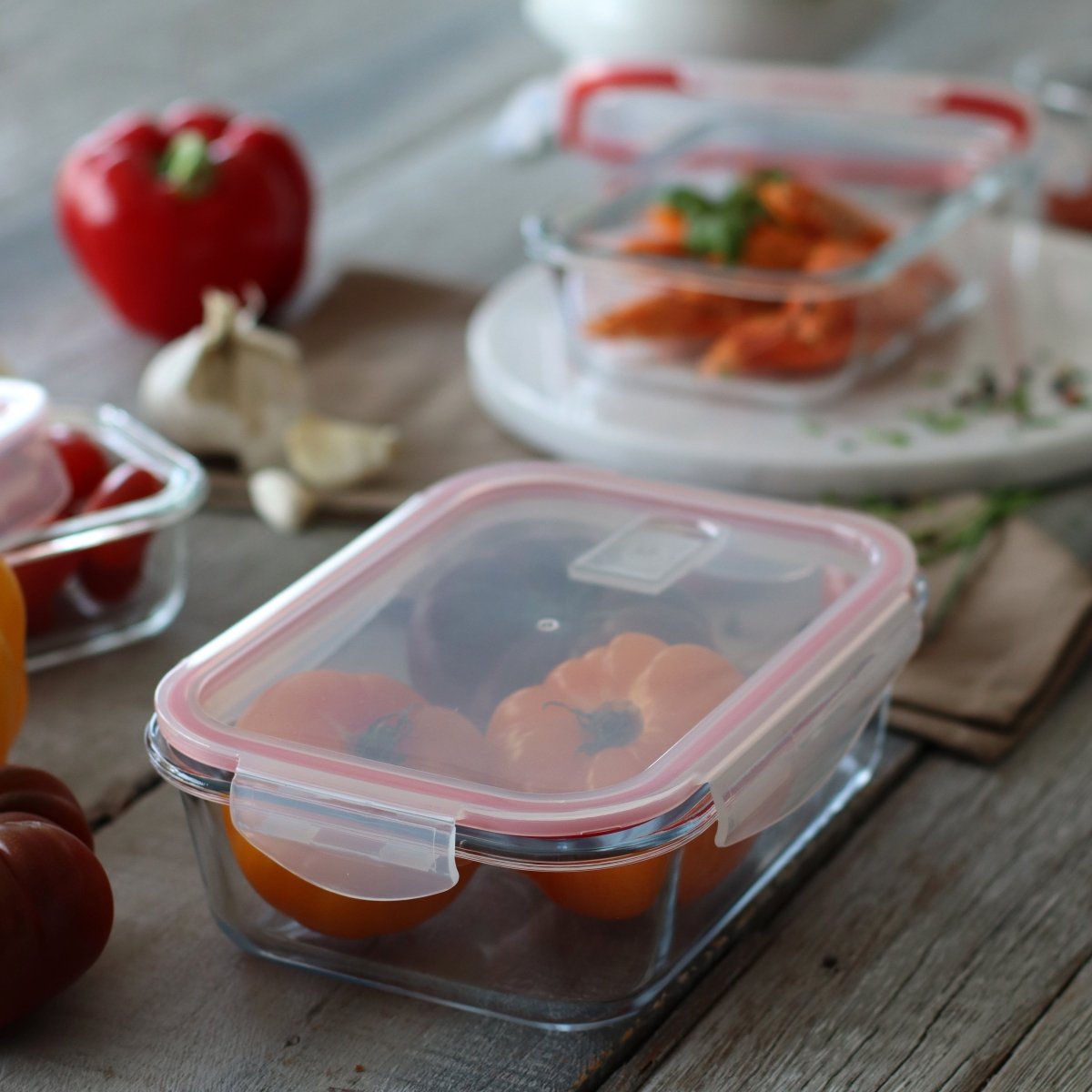 Boîte hermétique rectangulaire 630ml en verre avec couvercle transparent, posée sur table en bois avec légumes frais