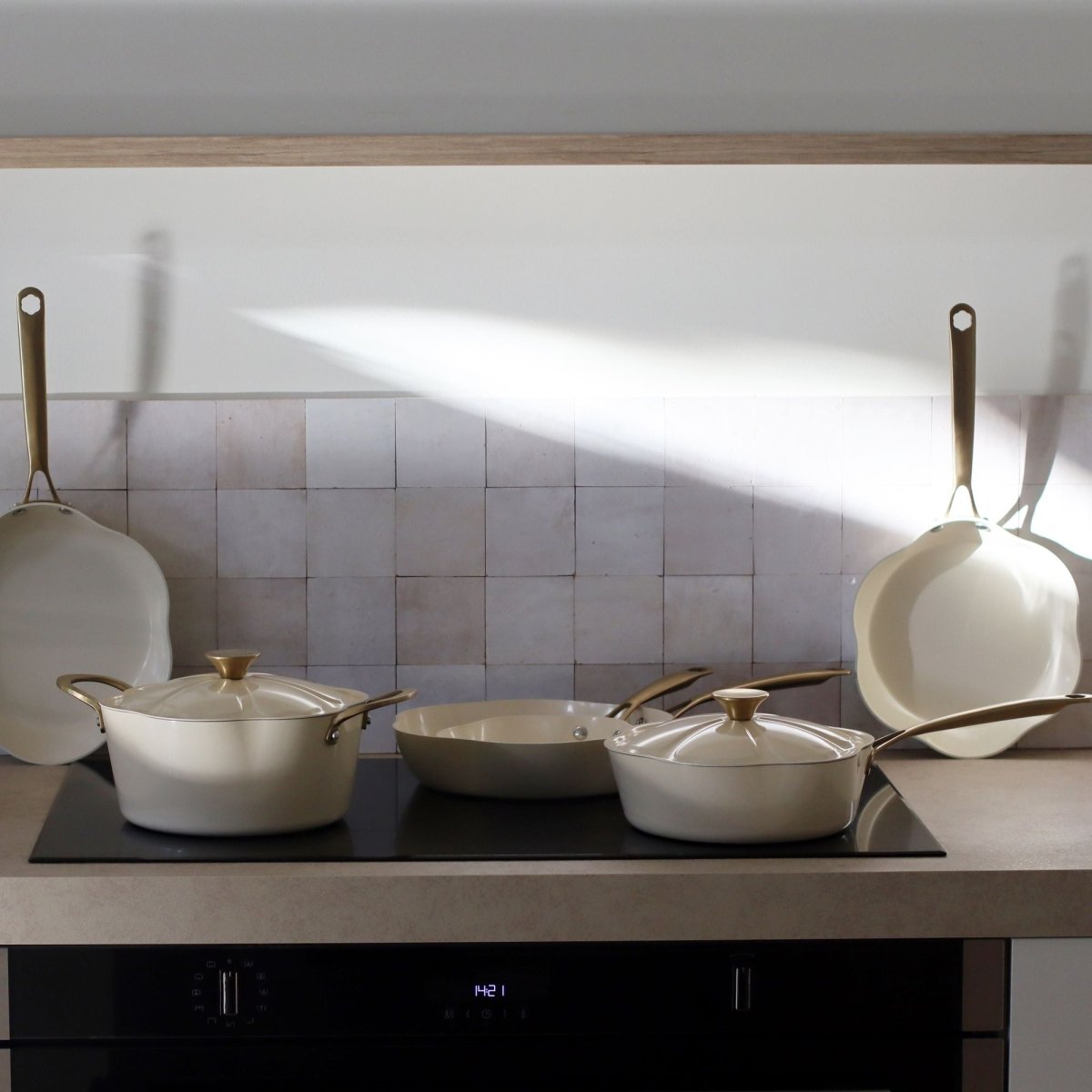 Set poêles et casseroles Dahlia beige en aluminium recyclé avec détails dorés sur plaque induction moderne