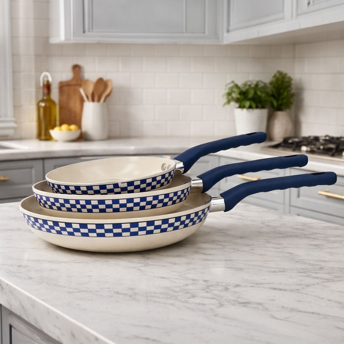 Set de trois poêles Ginette empilées avec motif à carreaux bleu et blanc, revêtement antiadhésif sans PFAS, manches bleu marine