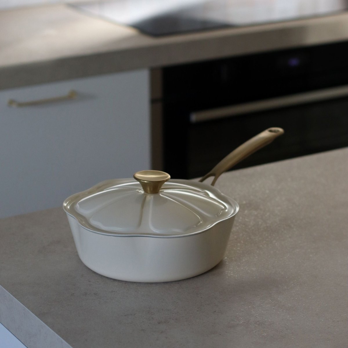 Sauteuse Dahlia 24 cm beige avec couvercle en verre posée sur plan de travail gris clair