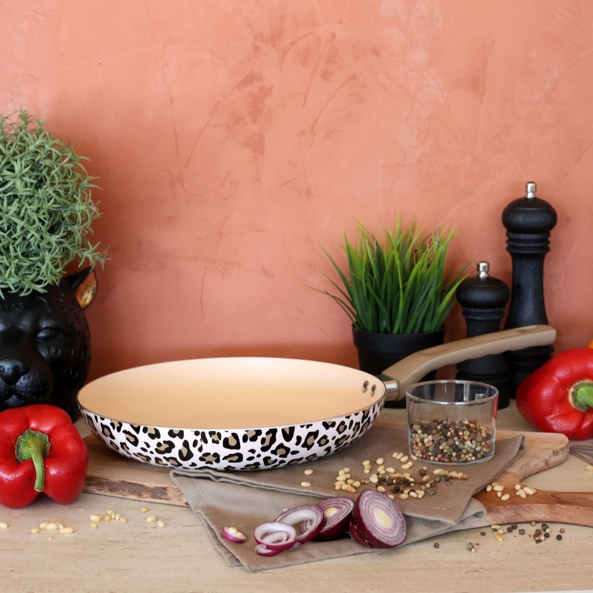 Set de 5 pièces Léopard avec poêle motif marron, ustensiles de cuisine et légumes frais sur fond terracotta
